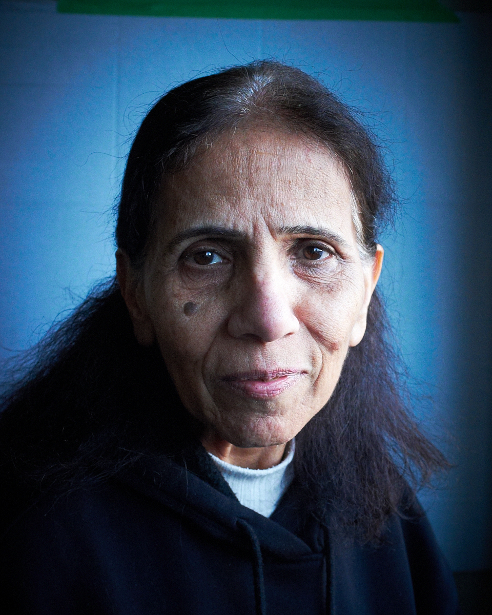 Elderly woman with long hair, wearing a hoodie.
