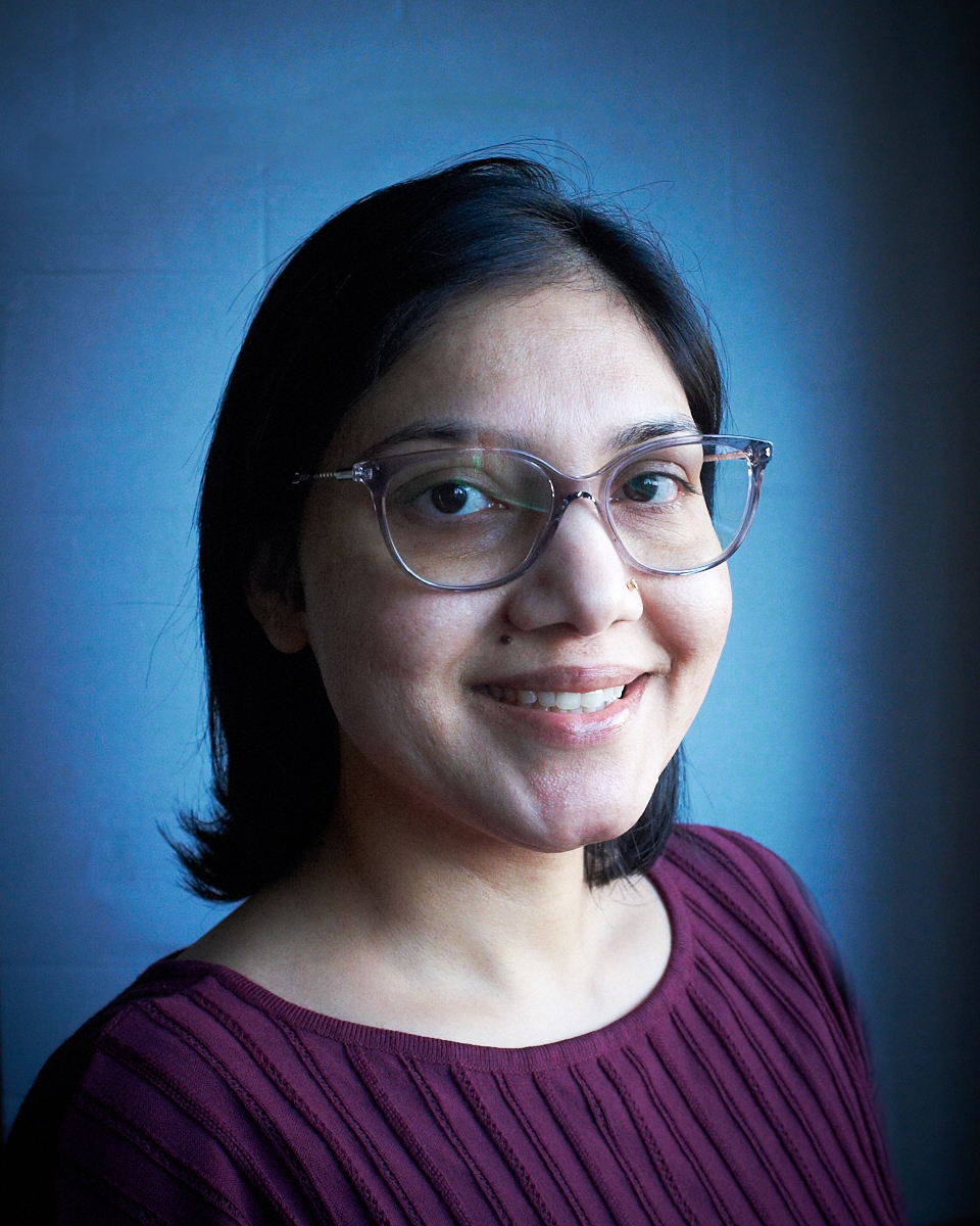 Smiling person wearing glasses, side profile view